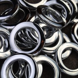 Pile of chrome metal grommet rings close up
