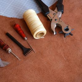 Leatherworking awl thread and tools on suede hide