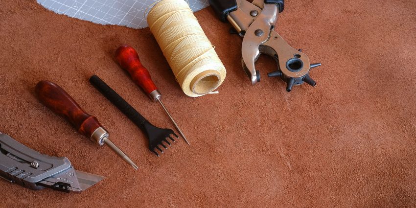 Leatherworking awl thread and tools on suede hide