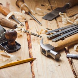 Vintage hand plane, chisels, and hammer on wooden workbench